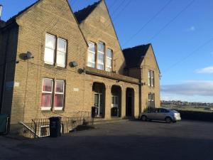 a brick building with a car parked in front of it at The Lookout@brighouse in Brighouse