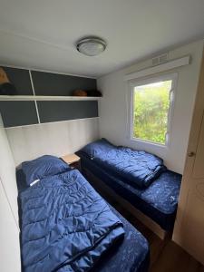 a small bedroom with two beds and a window at RBR 1023 - Beach Resort Kamperland in Kamperland