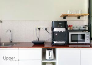 eine Küchentheke mit Kaffeemaschine und Mikrowelle in der Unterkunft Upper Residence Homestay in Ujong Pasir Melaka, 4 bedrooms, 14pax in Malakka