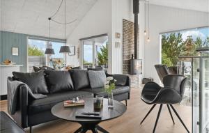 エーベルトフトにあるGorgeous Home In Ebeltoft With Wifiのリビングルーム(黒いソファ、テーブル付)
