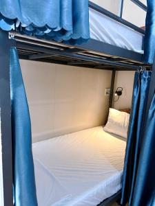 a bedroom with two bunk beds with blue curtains at New World Hotel in Hue