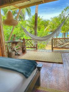 a hammock on a deck with a view of the ocean at TORTUGA BAY Eco Hotel in El Valle