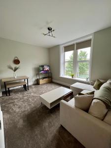 a living room with a couch and a table at The Lookout@brighouse in Brighouse