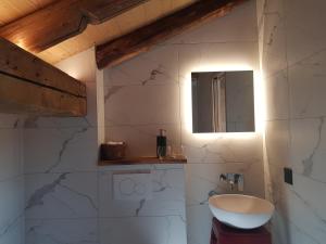 W łazience znajduje się biała umywalka i lustro. w obiekcie Aux fermes de la Croix, chambres, petits-déjeuners, diners w mieście Hauteluce