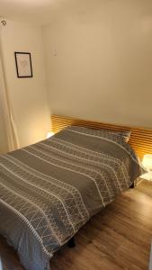 ein Schlafzimmer mit einem Bett mit einer grauen Decke in der Unterkunft L'Edelweiss Campus & Parking privé securisé in Gières