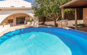 a large blue swimming pool in front of a house at Gorgeous Home In Roda De Bara With Kitchen in Roda de Bará