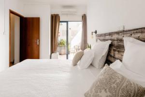 a bedroom with a large white bed with white pillows at Anna's Apartment Praia da Rocha in Portimão