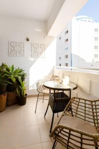 a balcony with a table and chairs and a window at Anna's Apartment Praia da Rocha in Portimão