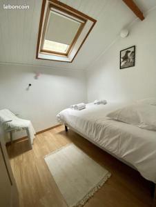 a white bedroom with a bed and a window at L'Atypique T3 Stanislas Maisonnette avec cour in Orléans