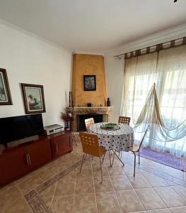 sala de estar con mesa, sillas y TV en RITSA APARTMENT en Perea