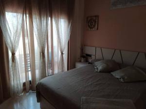 a bedroom with a bed and a window with curtains at Bajo puerta de Alcazaba in Retamar +23 photos