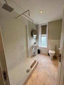 een badkamer met een glazen douche en een toilet bij The Lookout@brighouse in Brighouse