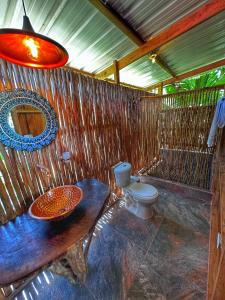 baño con aseo y pared de madera en TORTUGA BAY Eco Hotel en El Valle