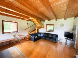 sala de estar con sofá negro y techo de madera en Remote Cabin in Nature en Nova Vas