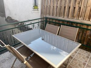 - Balcón con mesa de cristal y 2 sillas en L'Atypique T3 Stanislas Maisonnette avec cour en Orléans