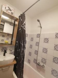 a bathroom with a shower curtain and a sink at Apartman Anamaria in Gospić