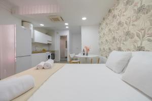 Cet appartement comprend une chambre avec un grand lit blanc et une cuisine. dans l'établissement For You Rentals Acogedor y Espacioso Estudio en Madrid GJR6, à Madrid