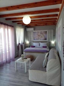 een slaapkamer met een bed, een bank en een tafel bij Marković Apartments (vidikovac) in Donji Milanovac