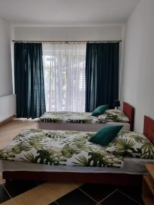 - 2 lits dans une chambre avec des rideaux bleus dans l'établissement Kolonijna Park, à Międzyzdroje