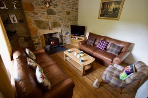 a living room with leather couches and a fireplace at Tigh Muileann in Killin