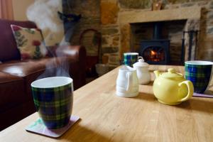 a wooden table with cups and a tea pot on it at Tigh Muileann in Killin