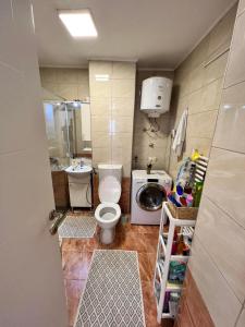 a small bathroom with a toilet and a washing machine at ELITE Brcanska Malta in Tuzla