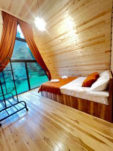1 dormitorio con 1 cama en una cabaña de madera en Collodi Cottages, en Tba