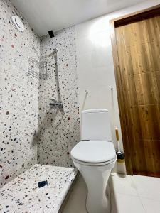 a bathroom with a white toilet and a shower at Collodi Cottages in Tba