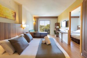 a hotel room with a couch and a bed at Golden Avenida Family Suites 4* in Salou