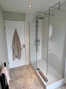 een badkamer met een douche en een glazen deur bij The Lookout@brighouse in Brighouse