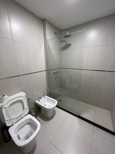 y baño con aseo, lavabo y ducha. en Departamentos y monoambientes Santiago 115 en Neuquén
