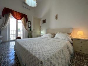 a bedroom with a large bed and a window at Piazzetta House in Capri