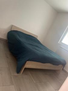 een bed met een blauwe deken bovenop een kamer bij L'espace détente in Beuvry
