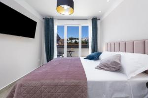 a bedroom with a bed with a tv and a window at Apartment & Rooms Primi with FREE PARKING in Dubrovnik +38 photos