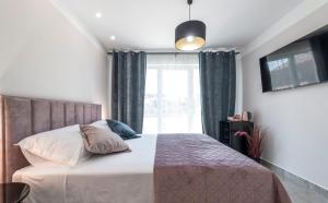a bedroom with a bed with a large window at Apartment & Rooms Primi with FREE PARKING in Dubrovnik