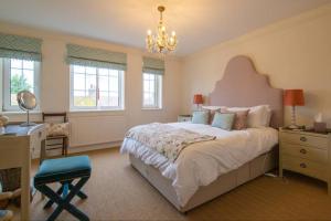 a bedroom with a large bed with a desk and a chair at Loke Cottage - Winchelsea Nr Rye in Winchelsea