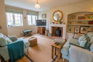 sala de estar con 2 sofás y chimenea en Loke Cottage - Winchelsea Nr Rye, en Winchelsea