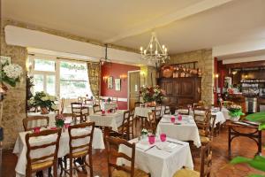 a dining room with white tables and chairs at Le Terminus des Pèlerins in Rocamadour
