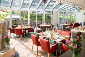 a restaurant with tables and chairs and windows at Family & Sporthotel Kärntnerhof in Bad Kleinkirchheim