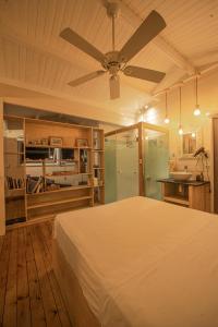 a bedroom with a bed and a ceiling fan at Between2Waters Chalet rental car offered in Tamarin