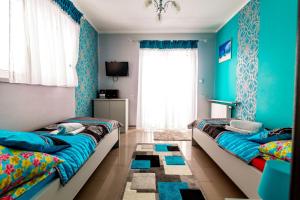 2 łóżka w pokoju z niebieskimi ścianami w obiekcie Jagodowy Domek w miejscowości Święta Katarzyna
