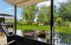 einen Tisch mit einer Schale Obst und einer Flasche Wein in der Unterkunft Beautiful Home In Ebeltoft With 5 Bedrooms, Sauna And Wifi in Ebeltoft