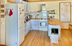 eine Küche mit weißen Geräten und einem weißen Kühlschrank in der Unterkunft Cozy Home In stra mtervik With Wifi in Östra Ämtervik