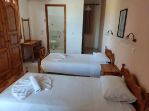 una camera d'albergo con due letti e un bagno di Nakellis Studios a Pétra