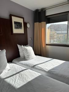 Postel nebo postele na pokoji v ubytování Hôtel Du Centre Annemasse