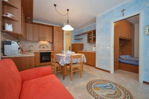 cocina y comedor con mesa en una habitación en Residenza Olimpo, en Lignano Sabbiadoro