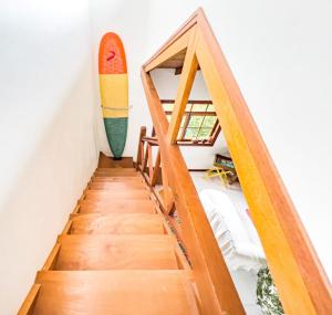 a stairway with a surfboard on the wall at Green Cottage Paraty in Paraty