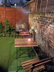 a picnic table with a candle next to a brick wall at Cozy 2 bed flat ! Amazing bath! in London