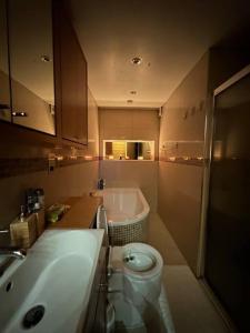 a bathroom with a tub and a toilet and a sink at Cozy 2 bed flat ! Amazing bath! in London