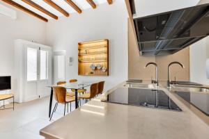uma cozinha com um lavatório e uma mesa em Alessia's Flat - Naviglio Grande 2 em Buccinasco